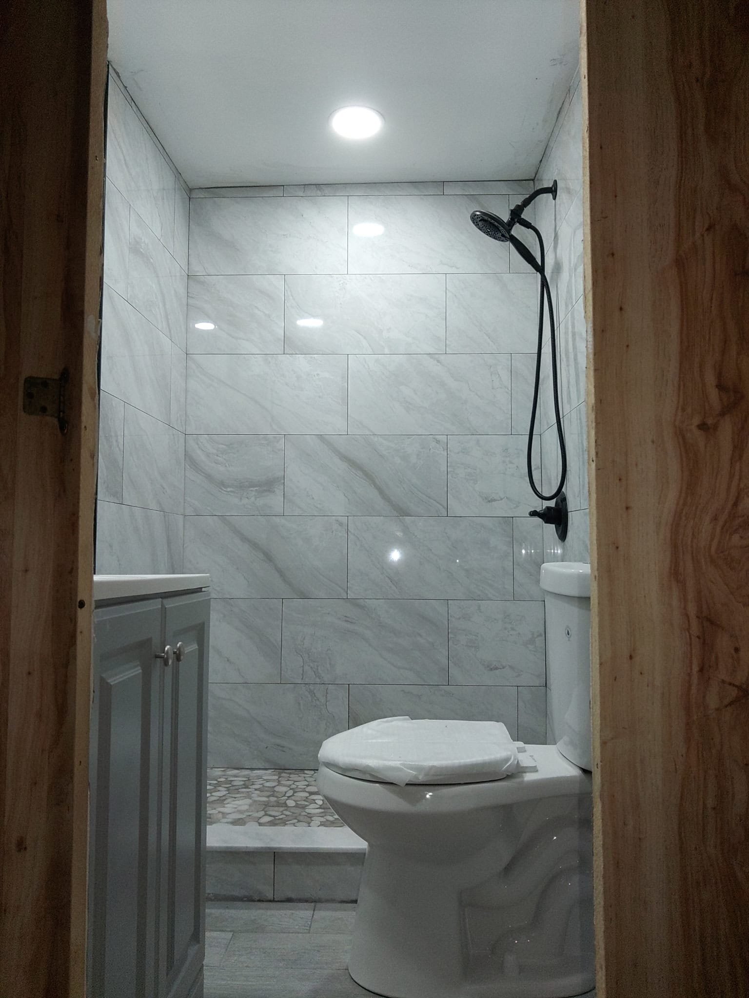 Bathroom renovation with tiled shower and black fixtures