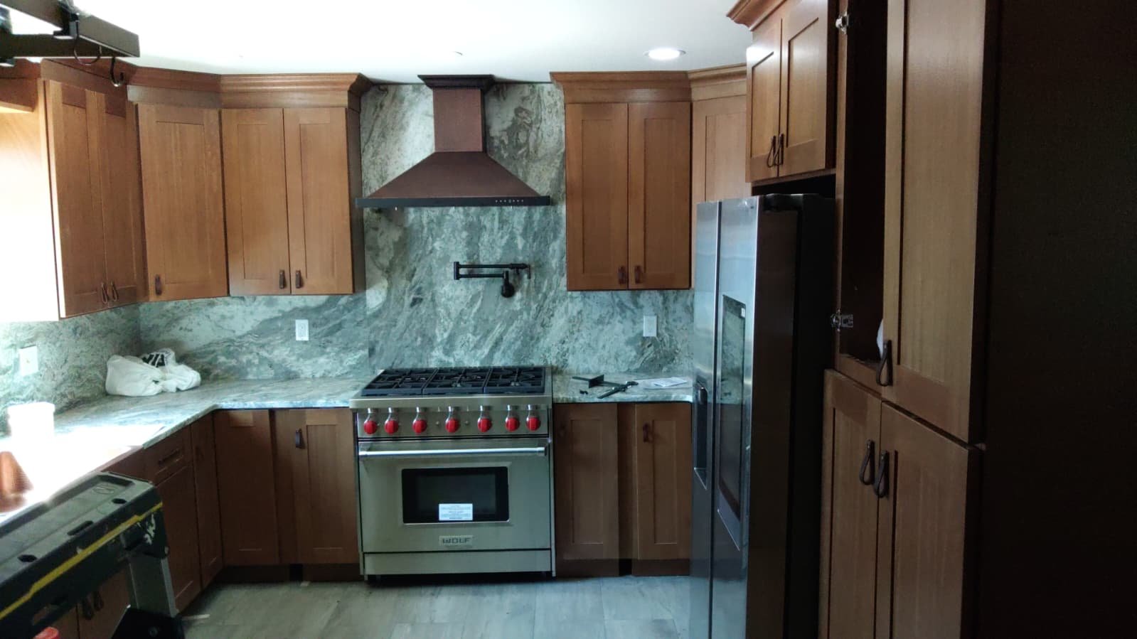 Kitchen renovation with wood cabinets and stone backsplash
